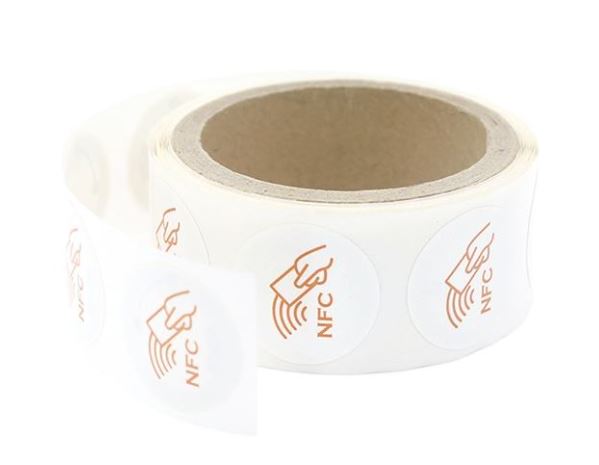Roll of NFC labels with gold symbols on a white background